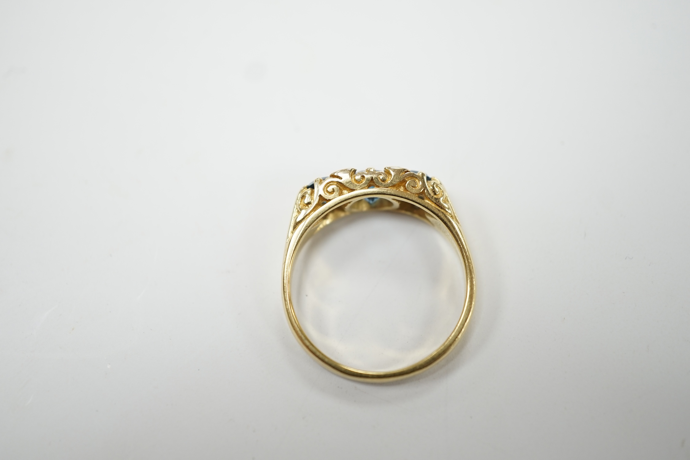 A modern Edwardian style 18ct gold and three stone blue topaz set ring, with diamond chip spacers, size M, gross weight 4.1 grams. Fair condition.